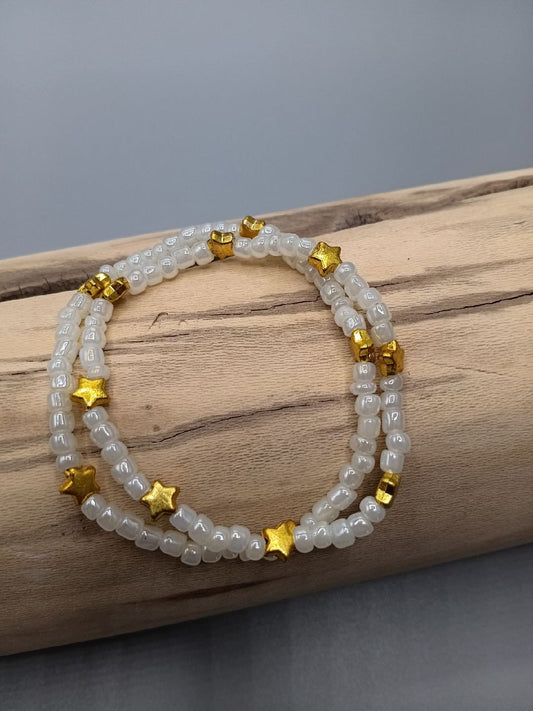 Bracelet double, perles blanches et étoiles dorées.